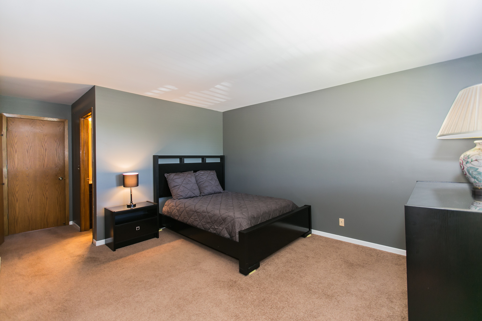 1903 West Golf Road, Unit 2A Mount Prospect, IL 60056 - Photo 10 of 20 a spacious bedroom with a bed and a lamp