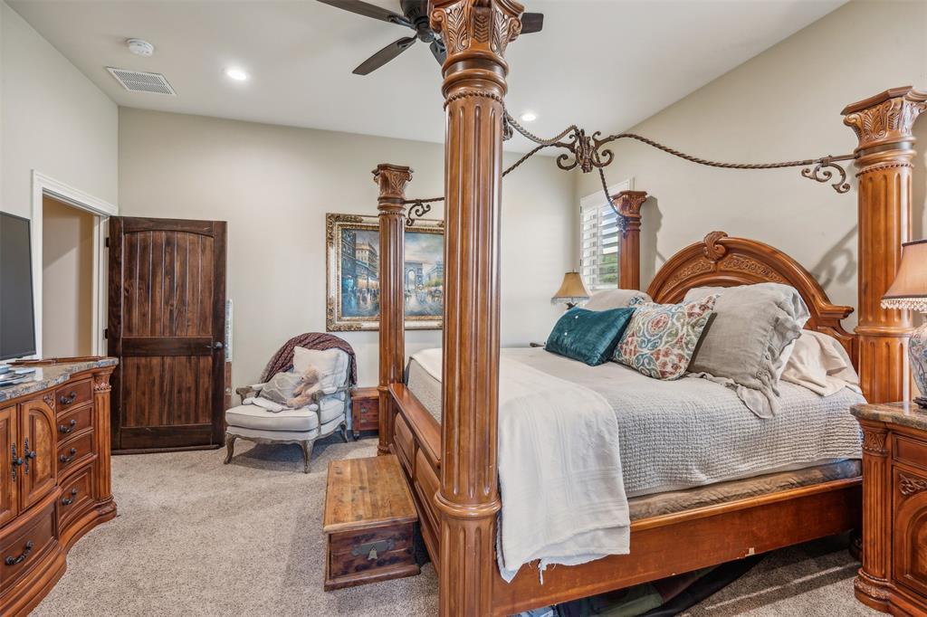 4180 North Smith Road Fate, TX 75087 - Photo 15 of 27 a bedroom with a bed and a chandelier