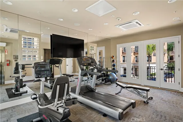a room with gym equipment and a flat screen tv