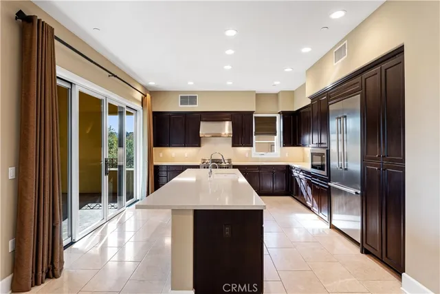 a large kitchen with a large counter top stainless steel appliances and cabinets