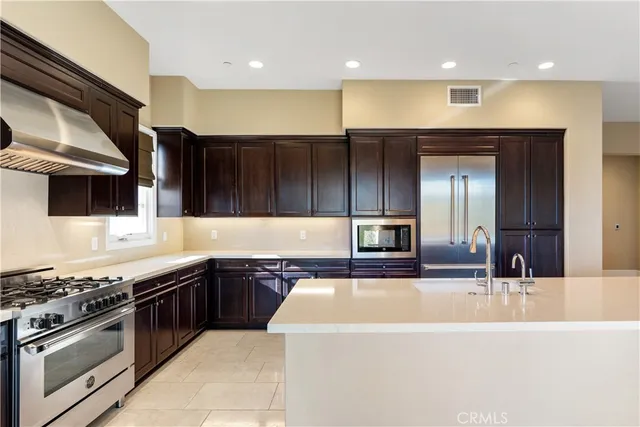 a large kitchen with stainless steel appliances and a kitchen island