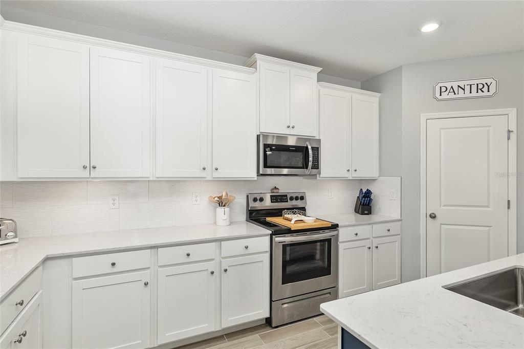 5688 Southwest 92nd Place Ocala, FL 34476 - Photo 19 of 54 a kitchen with white cabinets and white appliances
