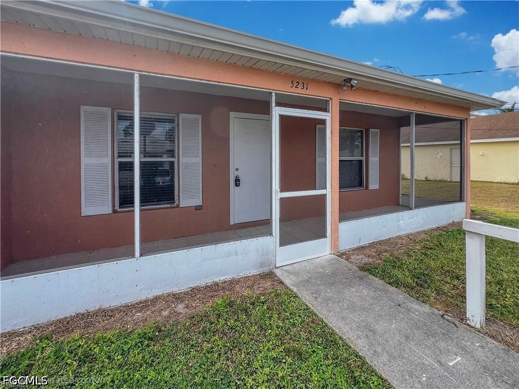 5231 27th Street Southwest Lehigh Acres, FL 33973 - Photo 1 of 22 a view of house with backyard porch and glass windows