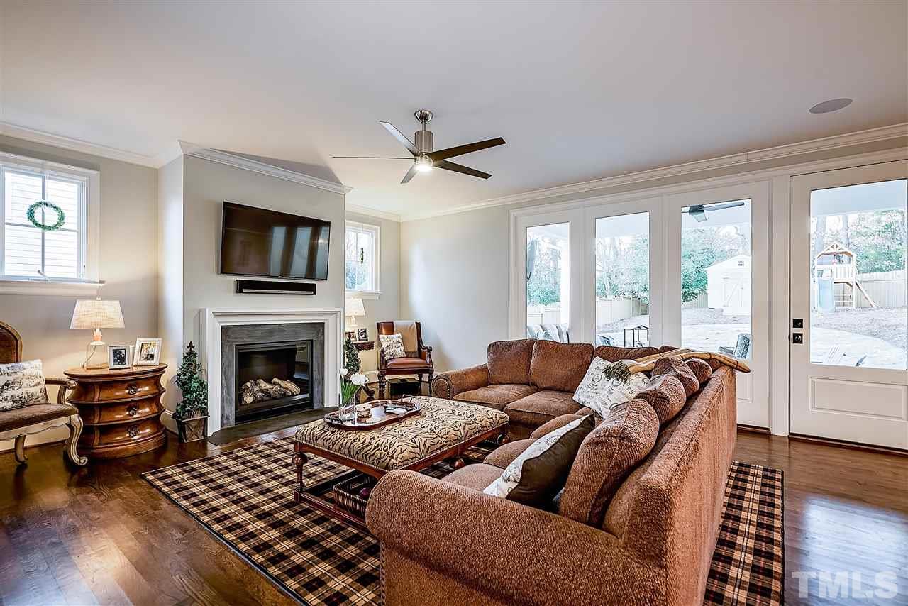217 Georgetown Road Raleigh, NC 27608 - Photo 11 of 25 a living room with furniture a fireplace and a flat screen tv