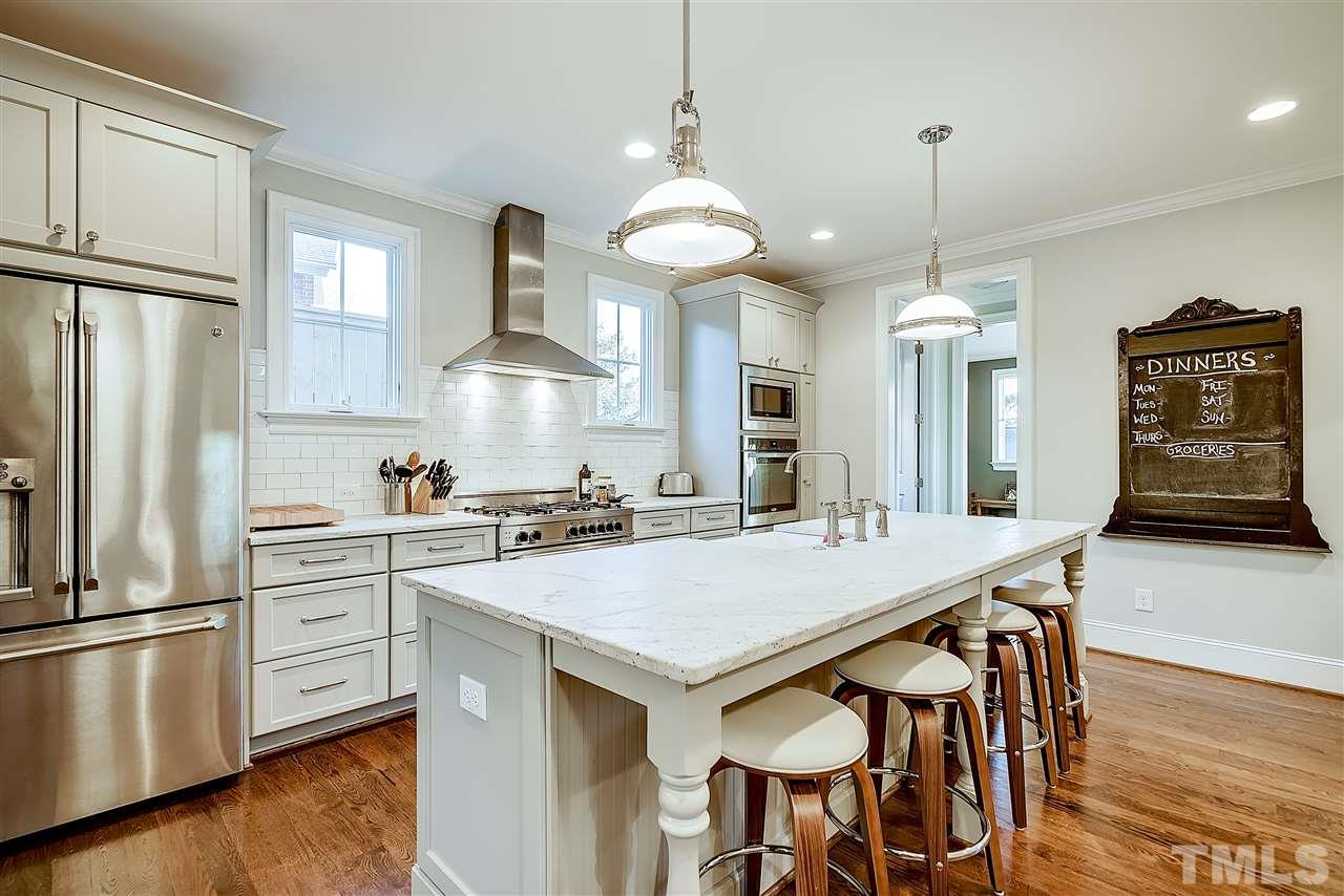 217 Georgetown Road Raleigh, NC 27608 - Photo 7 of 25 a kitchen with stainless steel appliances a stove a table and chairs