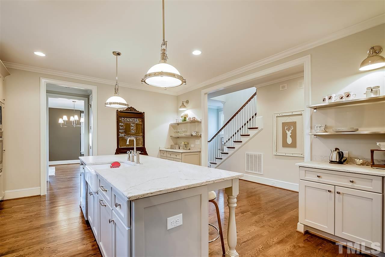 217 Georgetown Road Raleigh, NC 27608 - Photo 8 of 25 a kitchen view with white cabinets and wooden floor