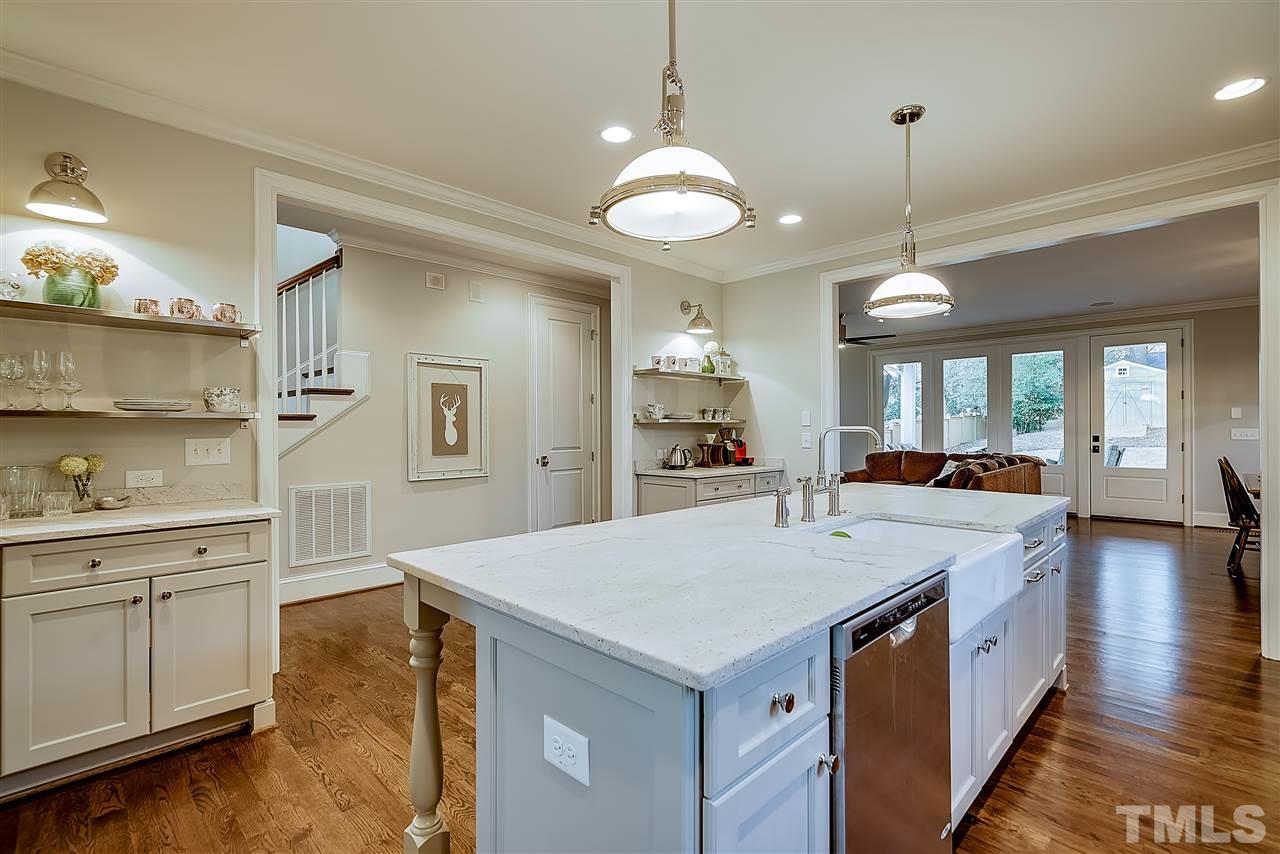 217 Georgetown Road Raleigh, NC 27608 - Photo 9 of 25 a large kitchen with kitchen island a stove a sink a center island and cabinets