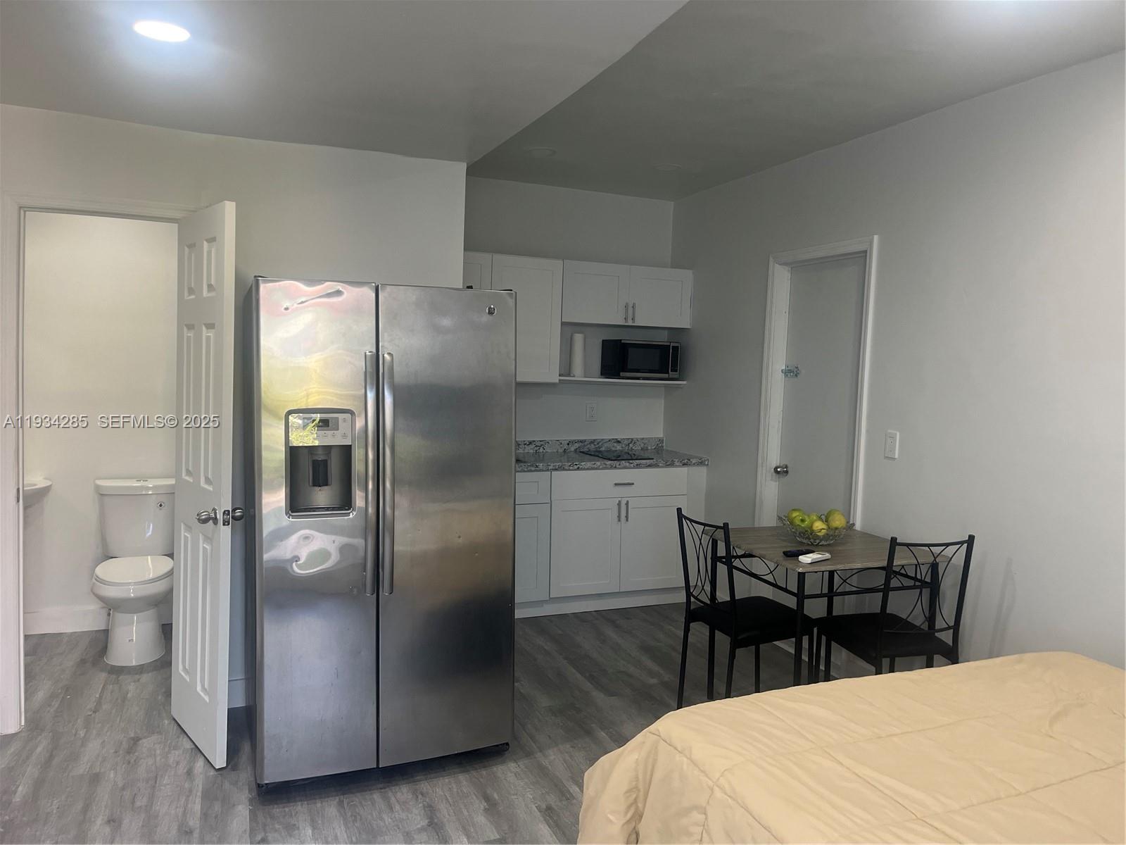 20766 Southwest 85th Place, Unit BACK Cutler Bay, FL 33189 - Photo 3 of 10 a kitchen with stainless steel appliances a refrigerator a stove a dining table and chairs