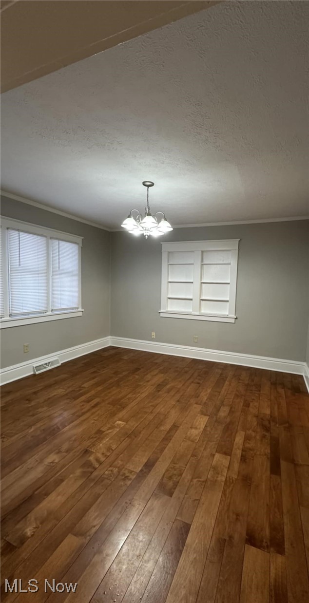 274 Ruckel Road Akron, OH 44305 - Photo 9 of 21 Unfurnished room with dark hardwood / wood-style flooring, crown molding, built in features, and a chandelier
