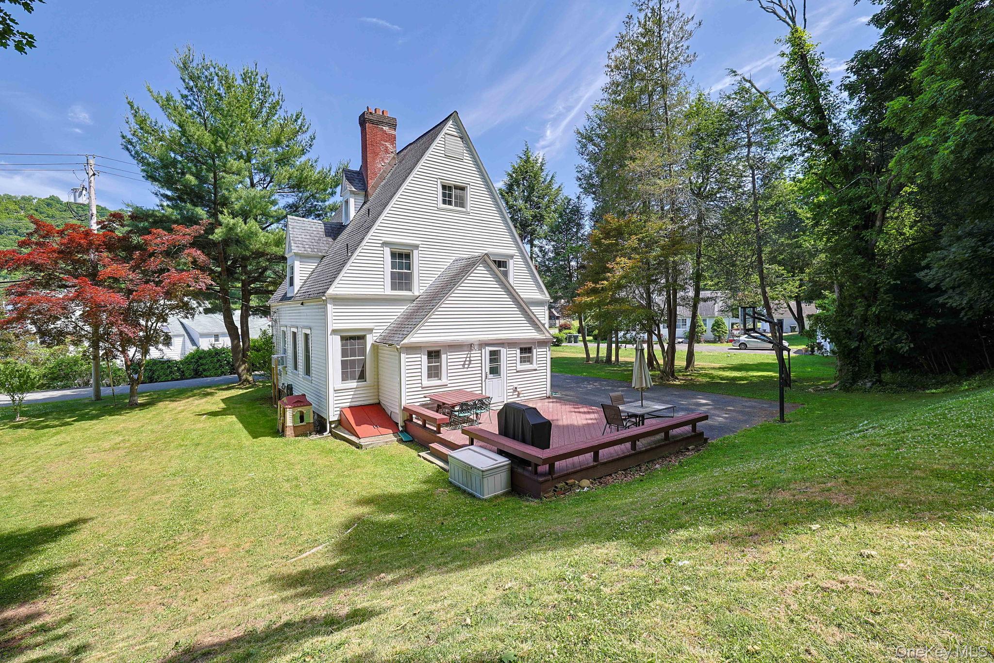 9 Library Road Tuxedo Park, NY 10987 - Photo 1 of 37 White-sided residence featuring a red brick chimney and a multi-level wood deck