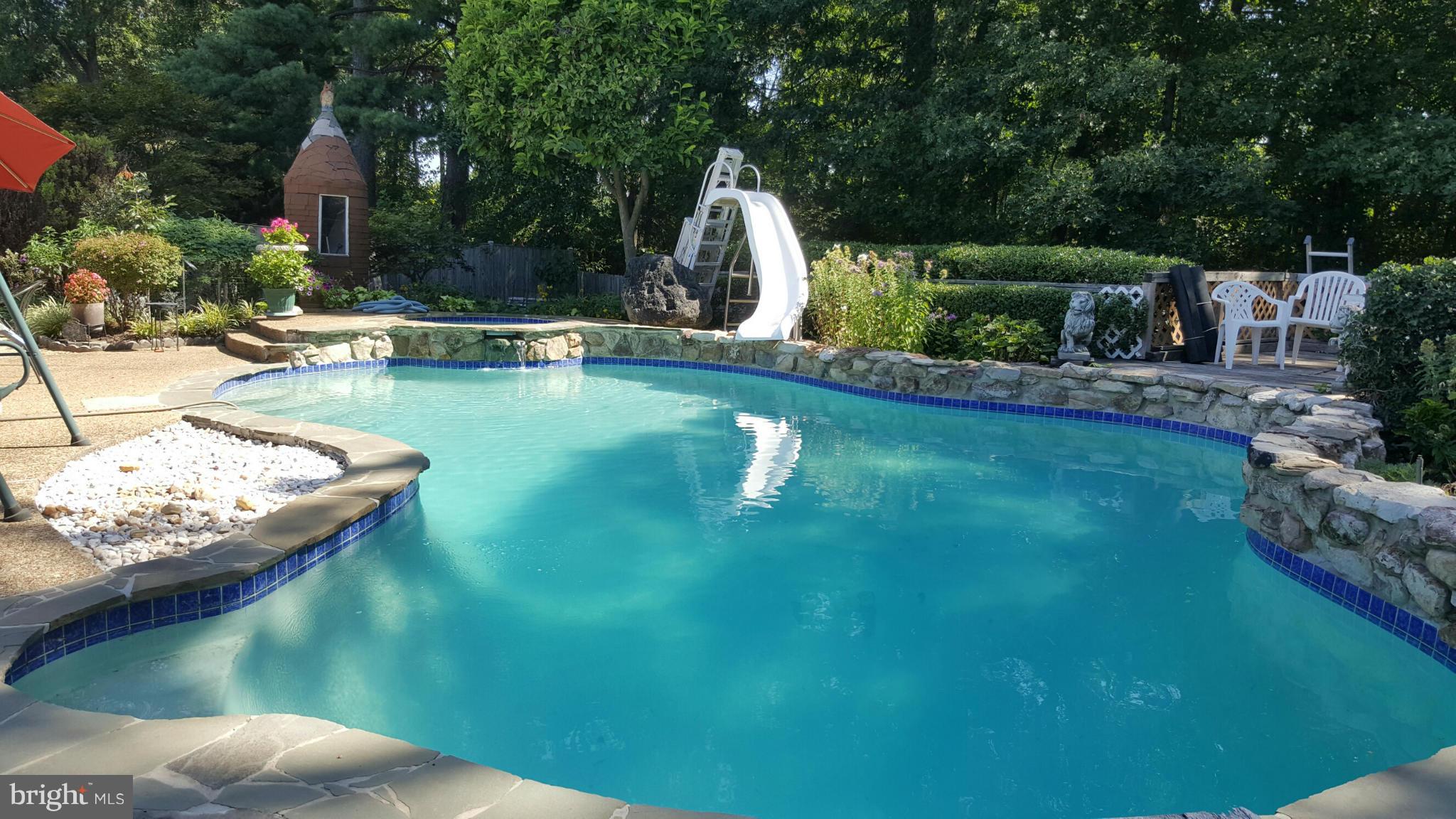 a swimming pool with barbeque oven outdoor seating and yard