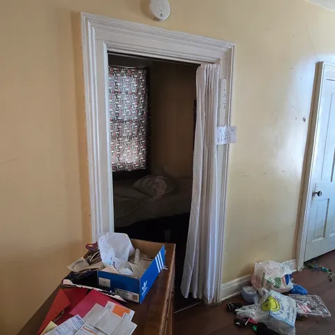 a living room with baby crib furniture and a window
