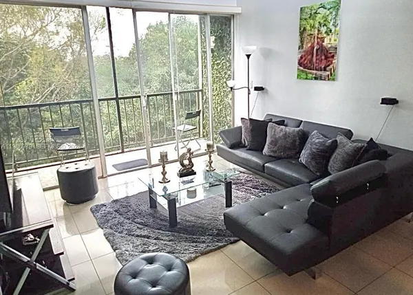 a living room with furniture and a floor to ceiling window