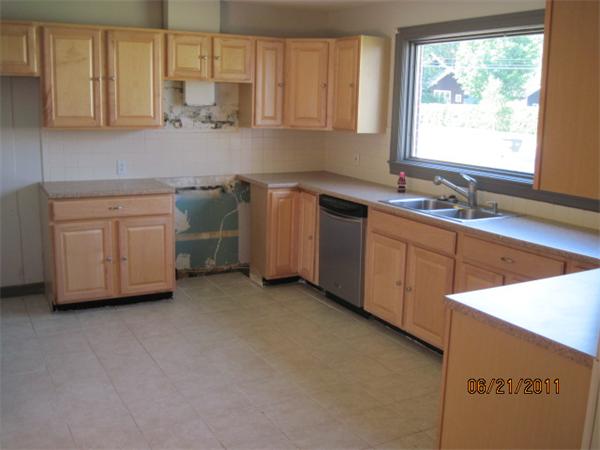 229 Oak Street Springfield, MA 01151 - Photo 2 of 10 a kitchen with white cabinets a sink and a stove