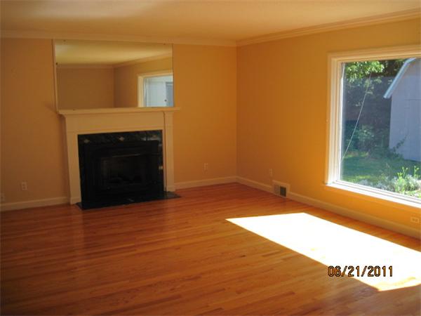 229 Oak Street Springfield, MA 01151 - Photo 3 of 10 a view of empty room with wooden floor and a fireplace