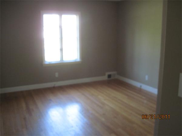 229 Oak Street Springfield, MA 01151 - Photo 7 of 10 an empty room with wooden floor and windows