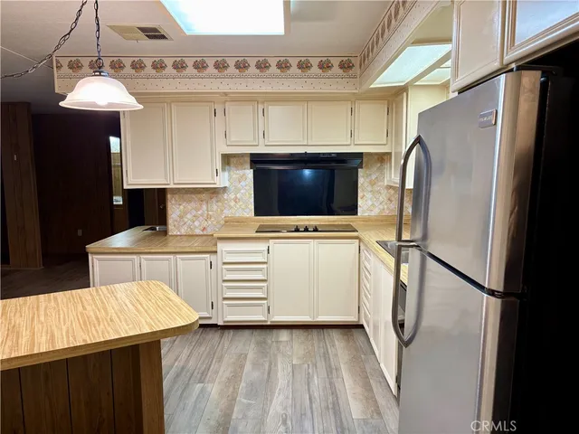 a kitchen with a refrigerator and a stove top oven