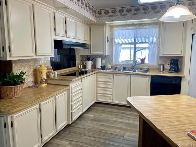 a kitchen with granite countertop a sink stainless steel appliances and cabinets