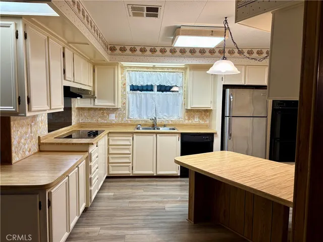 a kitchen with a sink refrigerator and cabinets
