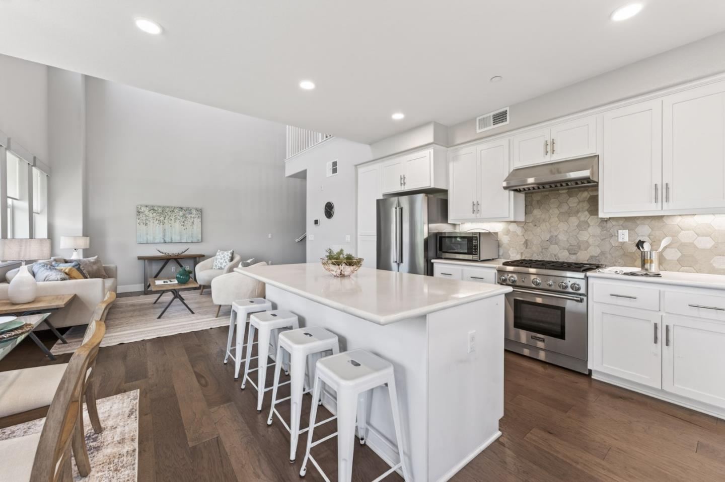 202 Market Street Milpitas, CA 95035 - Photo 5 of 30 a kitchen with stainless steel appliances kitchen island granite countertop a stove a sink a refrigerator and white cabinets with wooden floor