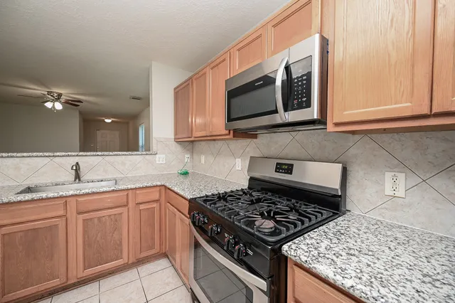 a kitchen with stainless steel appliances a stove a microwave a sink and cabinets
