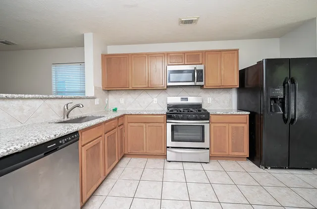 a kitchen with a sink stove and refrigerator