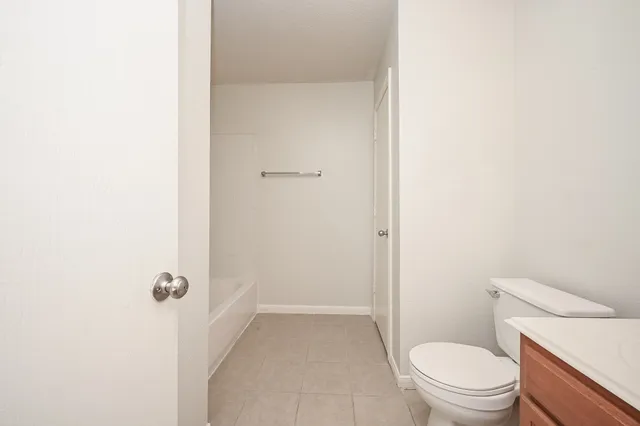 a bathroom with a granite countertop toilet and a shower