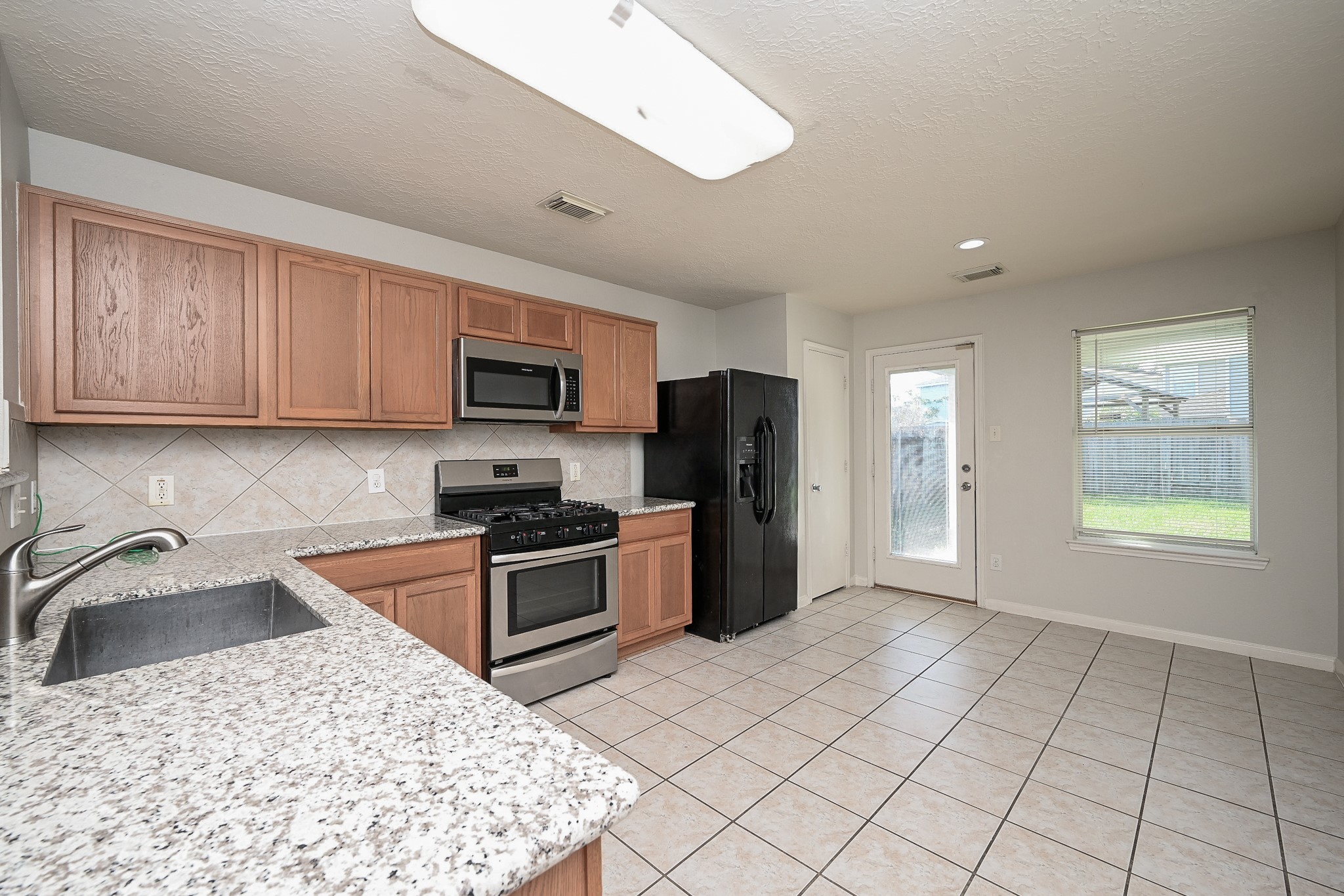 3635 Garrison Run Drive Spring, TX 77386 - Photo 7 of 32 Kitchen and breakfast area overlook the spacious backyard.