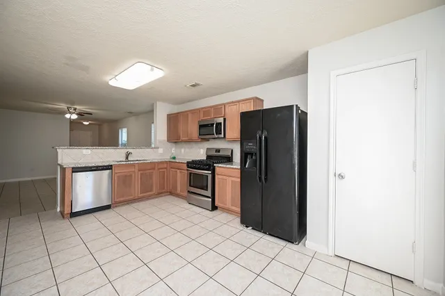 a kitchen with stainless steel appliances a refrigerator sink and cabinets