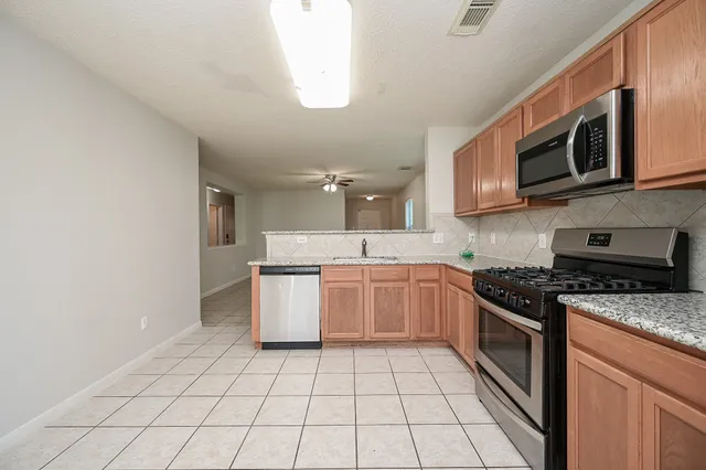 a kitchen with a sink a stove top oven and cabinets