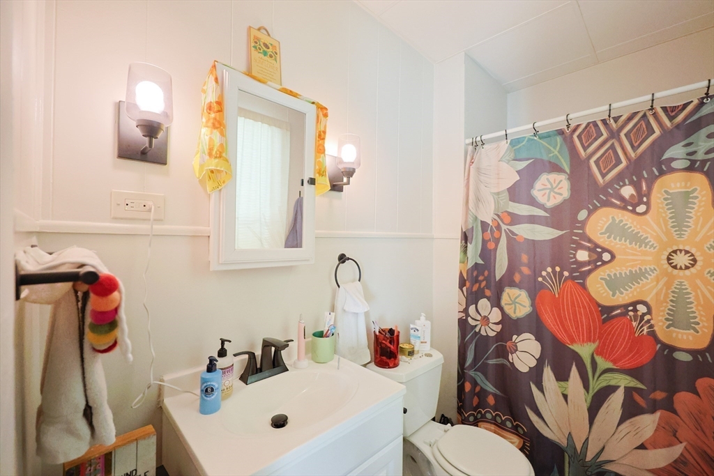 104 Grove Street Fall River, MA 02720 - Photo 9 of 37 a bathroom with a sink and mirror with toilet