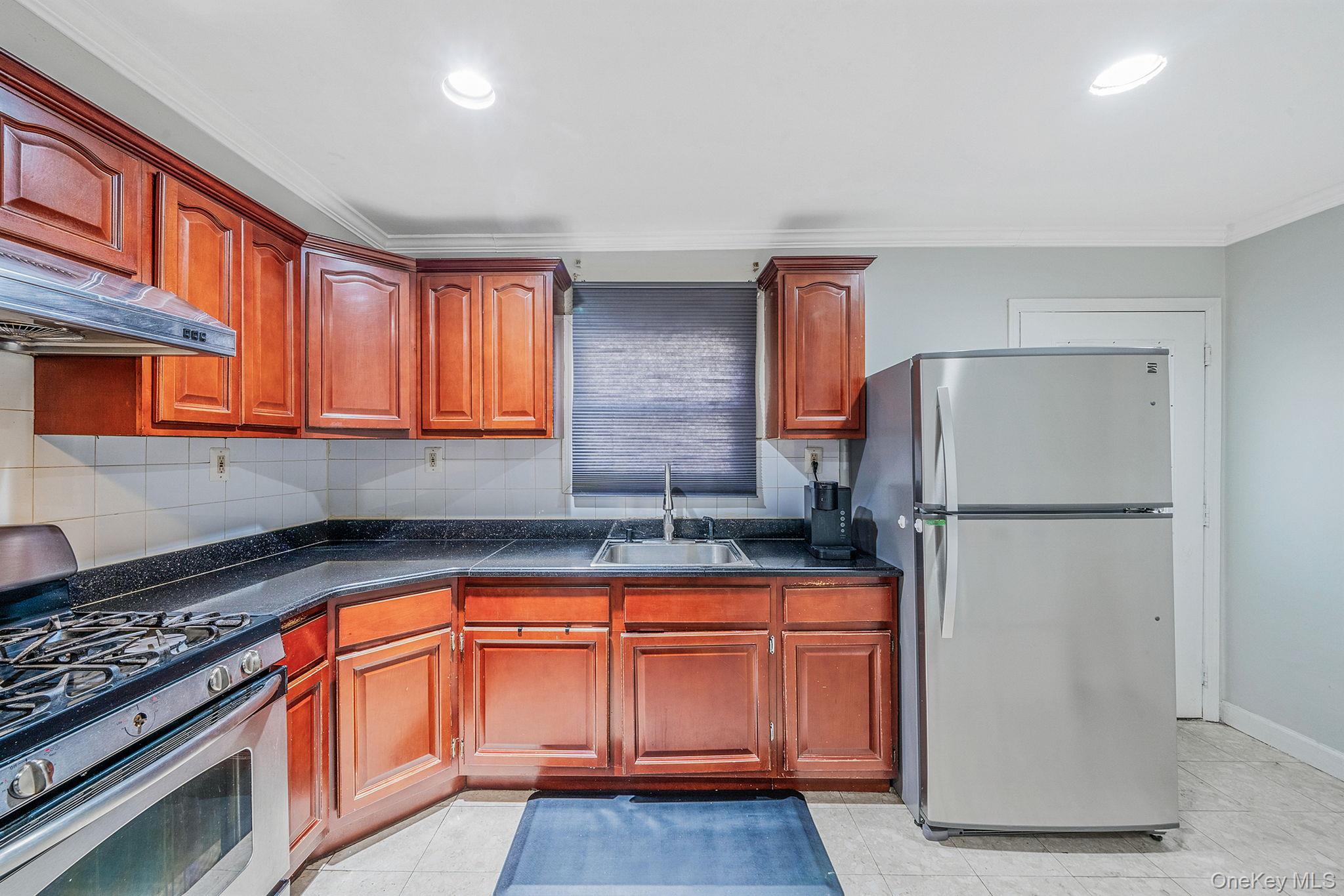 84-70 159th Street Queens, NY 11432 - Photo 22 of 50 Kitchen featuring stainless steel appliances, tasteful backsplash, ornamental molding, recessed lighting, and under cabinet range hood