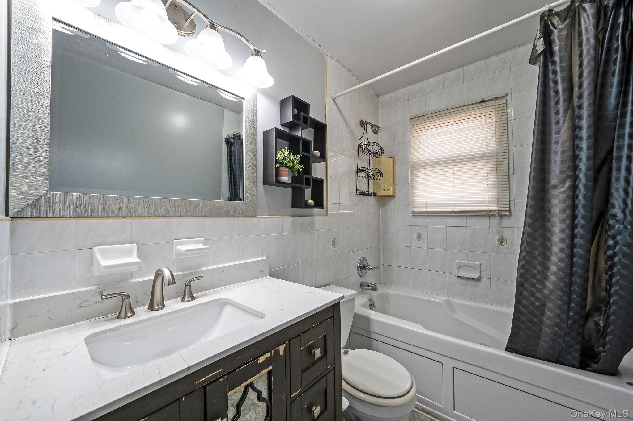 84-70 159th Street Queens, NY 11432 - Photo 24 of 50 Full bathroom with shower / tub combo, tile walls, and vanity