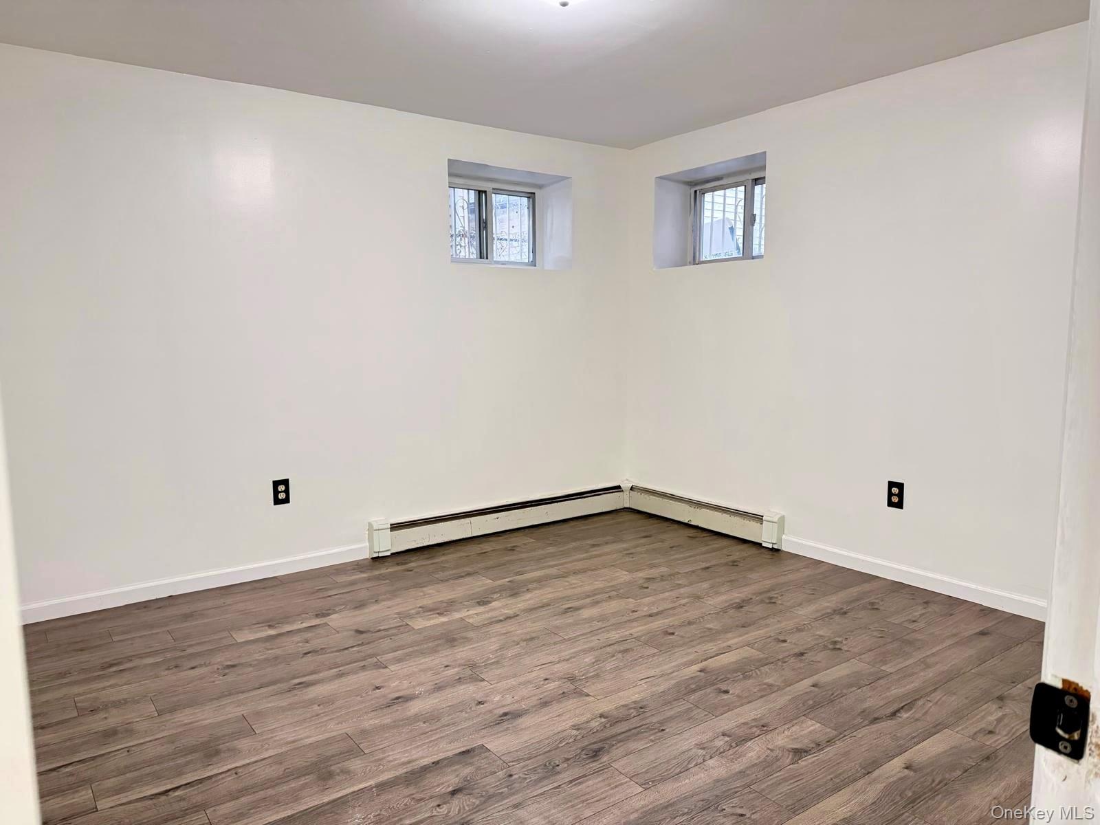 84-70 159th Street Queens, NY 11432 - Photo 27 of 50 Basement with wood finished floors and baseboard heating