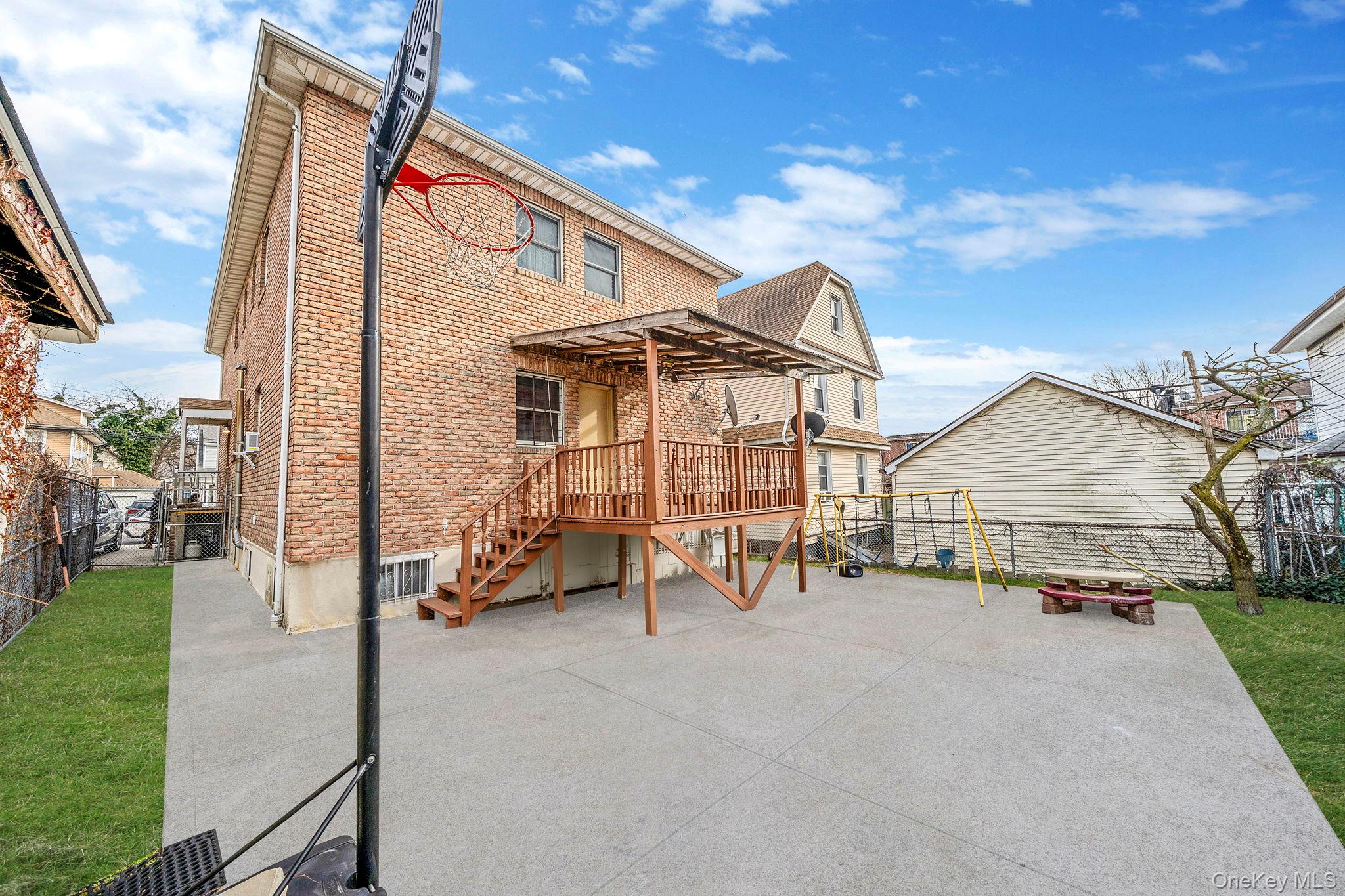 84-70 159th Street Queens, NY 11432 - Photo 37 of 50 Rear view of property with a fenced backyard, brick siding, a patio, stairway, and a deck
