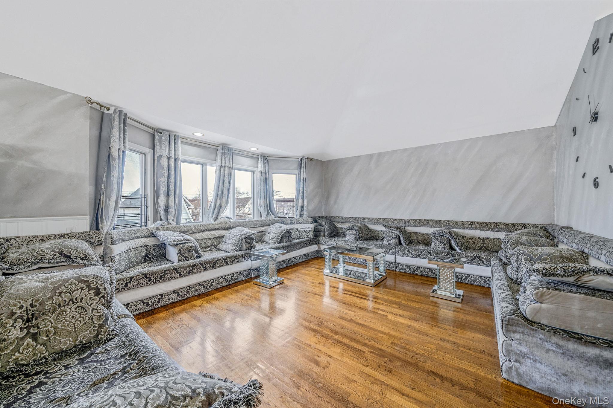 84-70 159th Street Queens, NY 11432 - Photo 4 of 50 Living area featuring light wood-style floors, lofted ceiling, a wainscoted wall, and recessed lighting