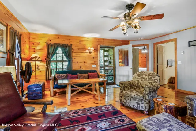 a living room with furniture a rug and a floor to ceiling window