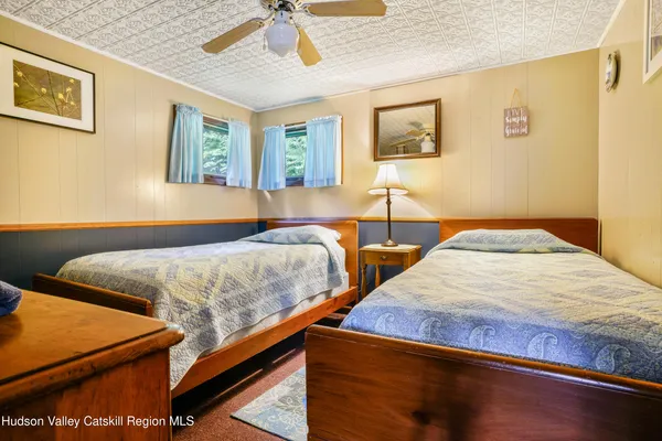 a bedroom with two beds and paintings on the wall