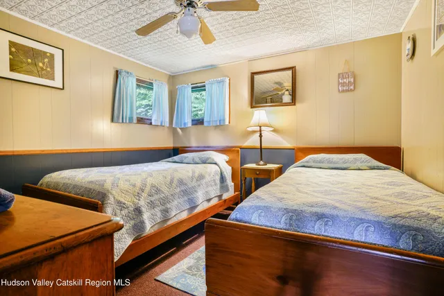a bedroom with two beds and paintings on the wall