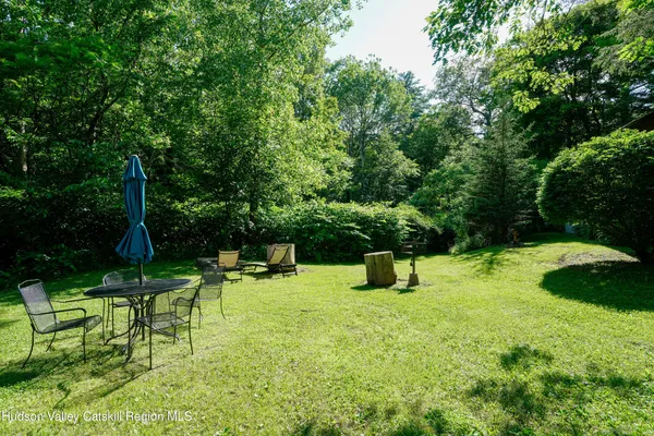 a backyard of a house with a yard and outdoor seating