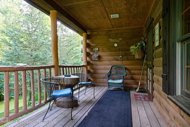 a balcony with wooden floor table and chairs