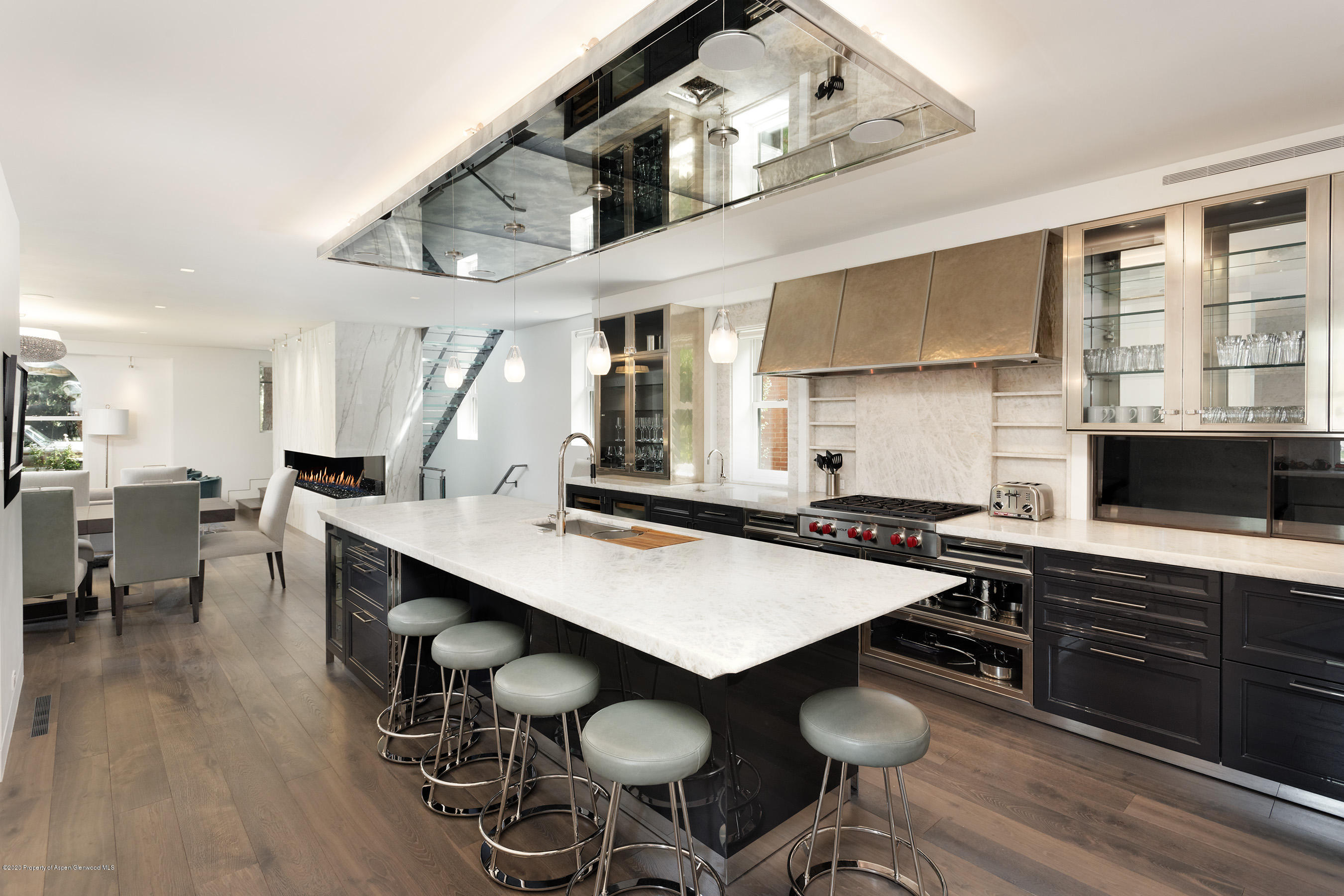 a kitchen with stainless steel appliances a table chairs sink and stove