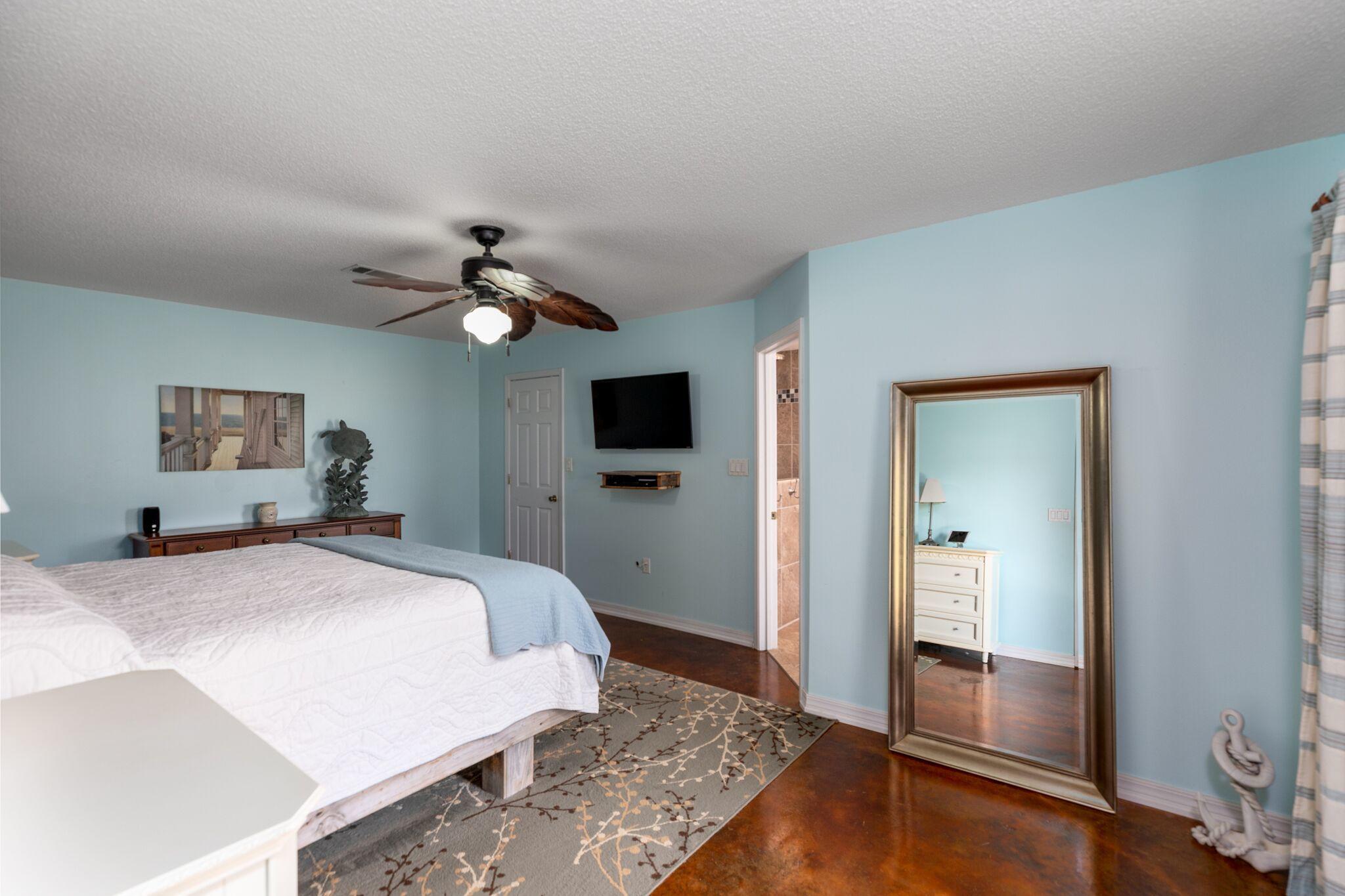 7780 Fenwick Street Navarre, FL 32566 - Photo 11 of 31 a spacious bedroom with a bed and a chandelier