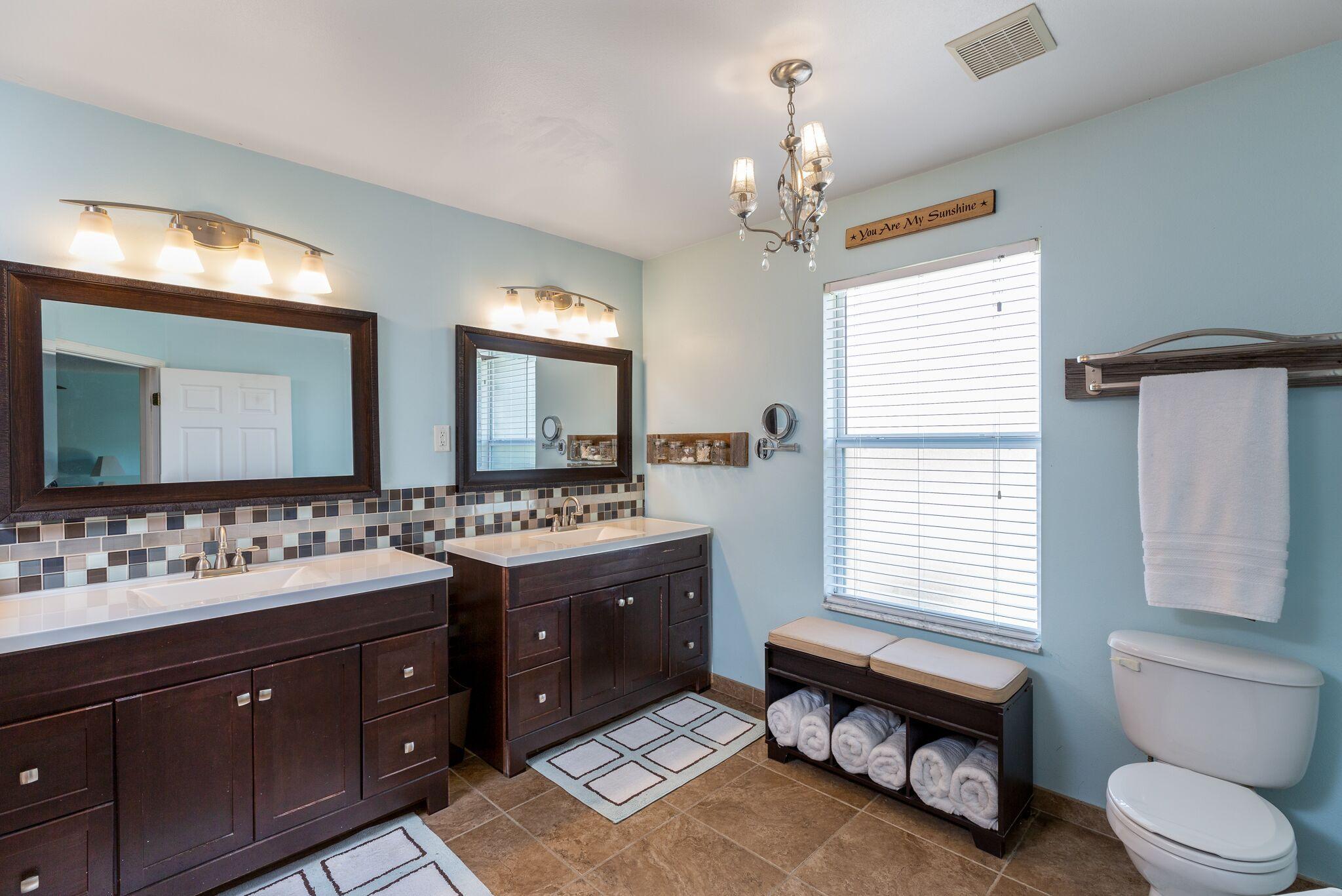 7780 Fenwick Street Navarre, FL 32566 - Photo 13 of 31 a spacious bathroom with a toilet a double vanity sink and a mirror