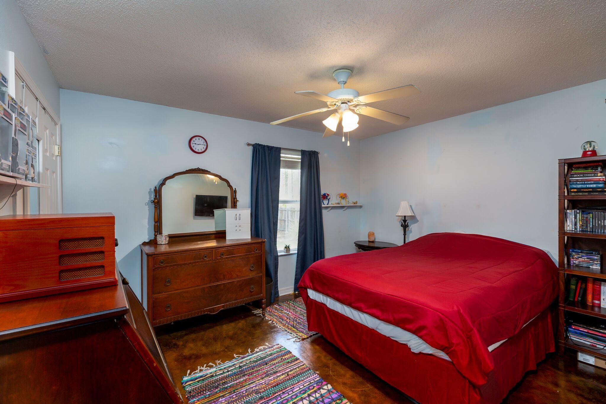 7780 Fenwick Street Navarre, FL 32566 - Photo 15 of 31 a bedroom with a bed and a chandelier