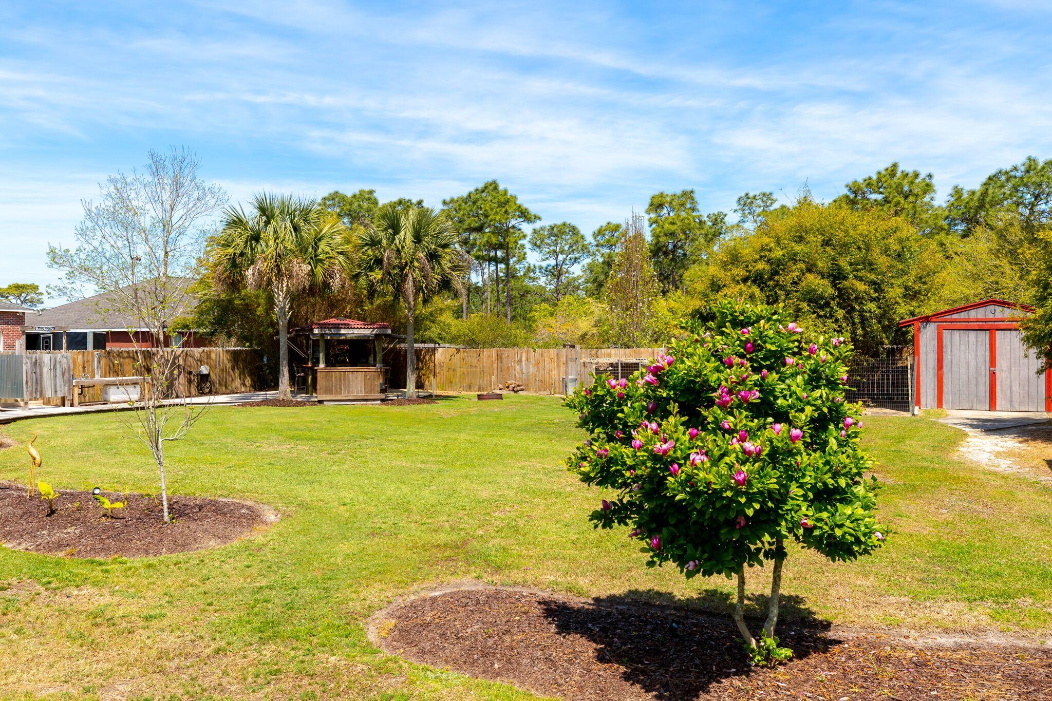 7780 Fenwick Street Navarre, FL 32566 - Photo 25 of 31 a view of a swimming pool with a garden