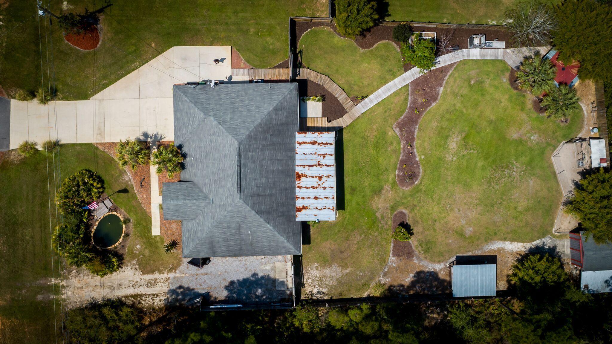 7780 Fenwick Street Navarre, FL 32566 - Photo 31 of 31 an aerial view of a house with a yard and greenery