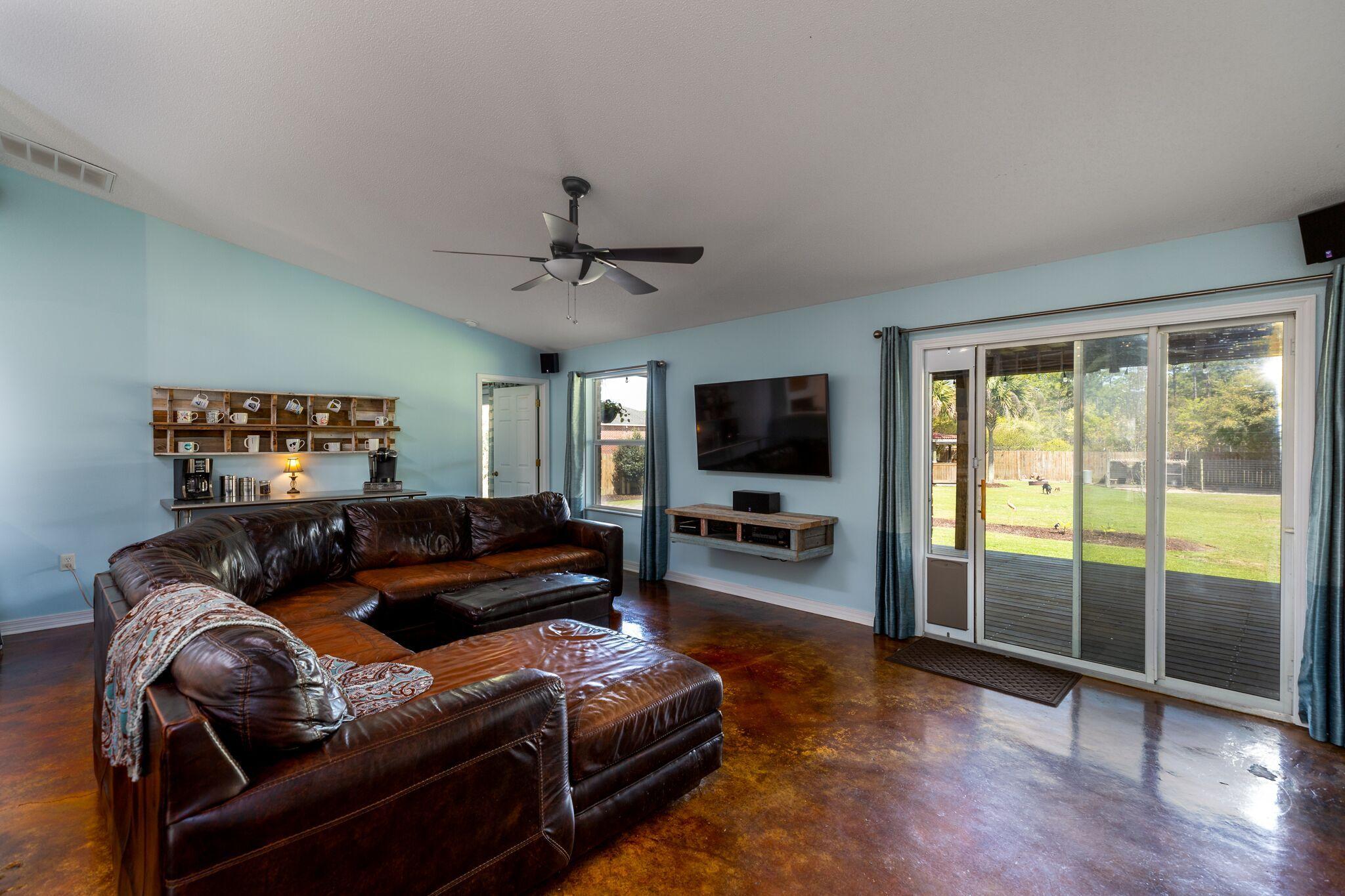 7780 Fenwick Street Navarre, FL 32566 - Photo 9 of 31 a living room with furniture and a flat screen tv