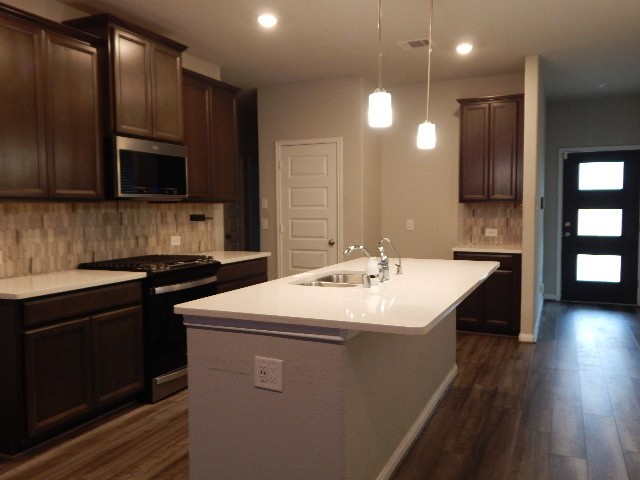 7103 Silverleaf Oak Street Conroe, TX 77304 - Photo 9 of 20 a kitchen that has a sink and a stove top oven