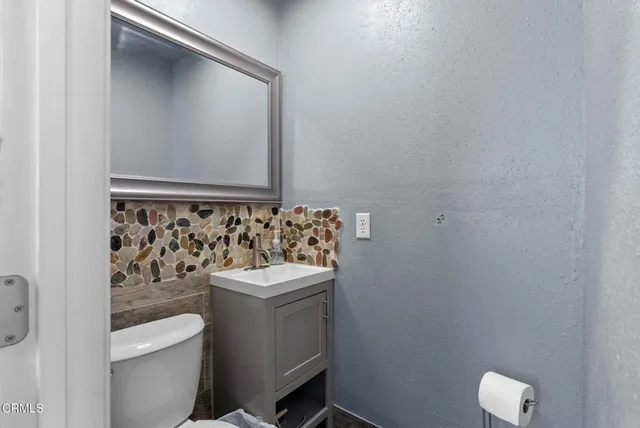 a bathroom with a sink a toilet and a mirror